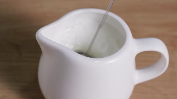 Ev yapımı latte, süt beyaz süt sürahisinde manuel kapuçino makinesiyle sulandırılır. - Video, Çekim