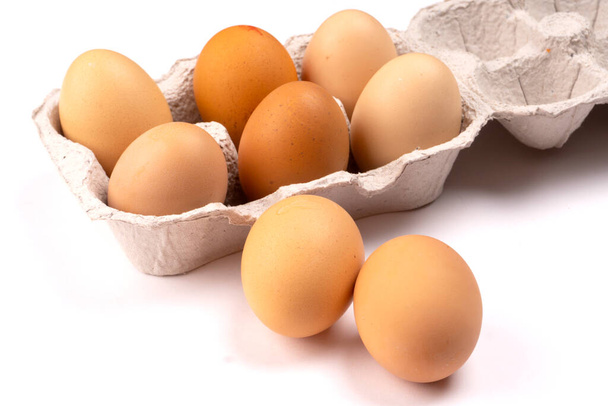 Barna tyúktojás kartondobozban. Organikus tojás az egészséges fehérje reggelihez. Húsvét szimbólum. Nyers tyúktojás. - Fotó, kép