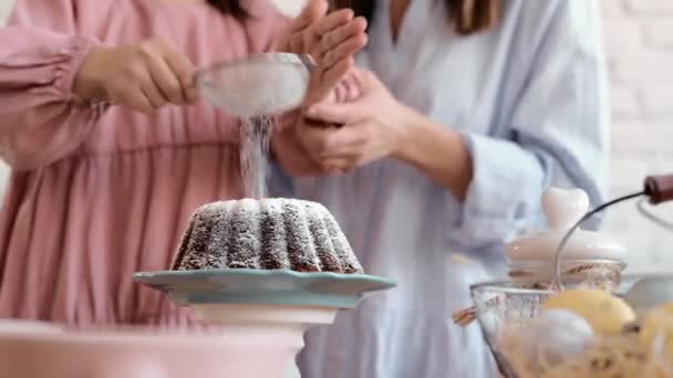 The girls hands are sitting on the ester. The mouth of the festival is Esther Brad Into Pieces. The girl decorates Esther Brad. Decorate the cake with icing sugar. Close-up - Footage, Video