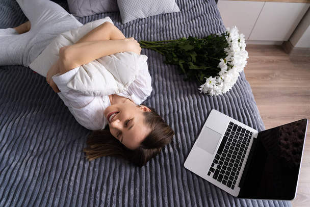 Kadınlar yatakta dizüstü bilgisayar kullanırken dinlenmenin keyfini çıkarırlar. - Fotoğraf, Görsel