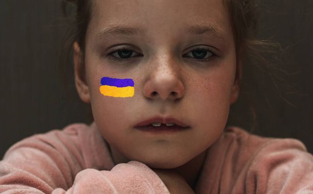Kind mit der Fahne der Ukraine weint. Traurigkeit sehnt sich nach Hoffnung. Evakuierung von Zivilisten. Freiheit für die Ukraine - Foto, Bild