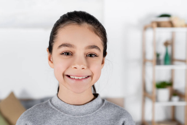 portrait of happy preteen girl looking at camera at home - Photo, Image