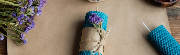 Top view kézzel készített gyertya száraz virágokkal kézműves papír fa felületen, banner  - Fotó, kép