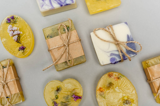 Top view of handmade soap bars with flowers and twine on grey background  - Fotoğraf, Görsel
