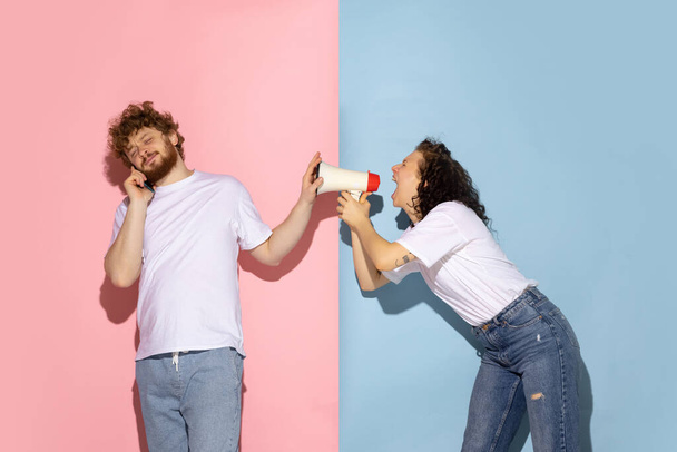 Married couple, young emotive man and girl isolated on blue and pink trendy color background. Human emotions, care, relationships concept - Fotoğraf, Görsel