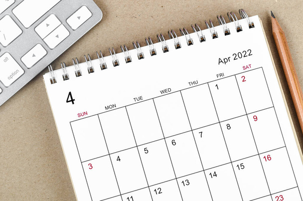 The April 2022 desk calendar with pencil on wooden background. - Foto, Imagen