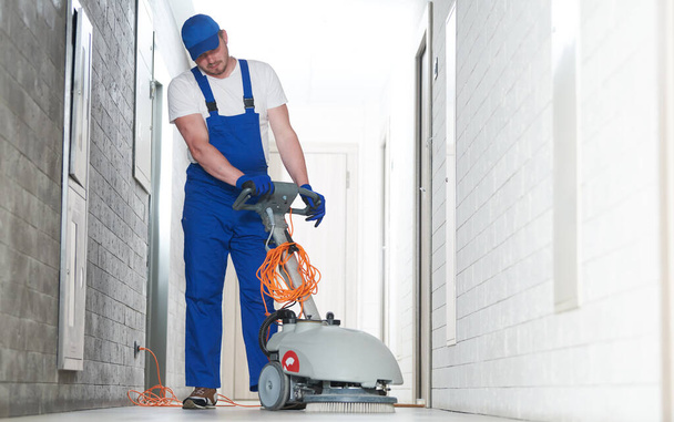 cleaning service. worker with machine cleaning floor in hallgarage - Zdjęcie, obraz