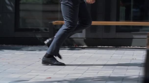 Un homme confiant qui court dans la rue en costume. Jambes masculines en chaussures noires gros plan. - Séquence, vidéo