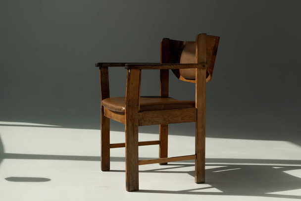 old vintage leather armchair in sunbeams and shadows - Φωτογραφία, εικόνα