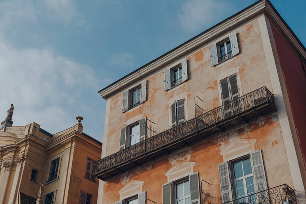 Fachada de edificio tradicional envejecido en el casco antiguo de Niza, Francia, en un día soleado, vista de ángulo bajo contra el cielo azul. - Foto, Imagen
