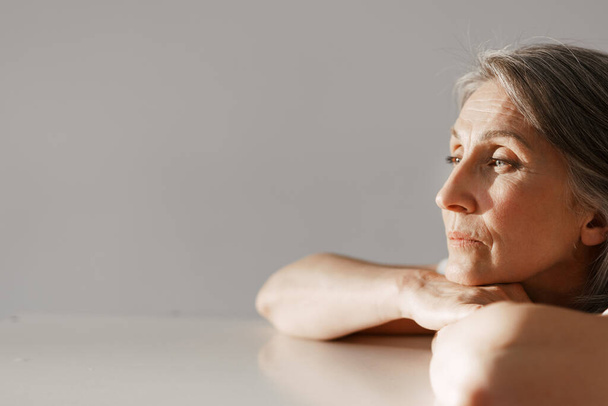 Európai idős nő ősz hajjal pózol és félrenéz elszigetelt fehér háttér - Fotó, kép