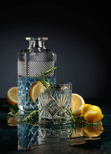 Gin tonic cocktail met citroen en rozemarijn. Kopieerruimte. - Foto, afbeelding