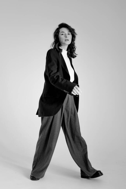 black and white portrait of young stylish woman wearing wide pants and jacket - Foto, immagini