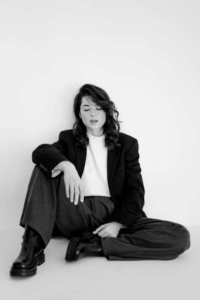 black and white portrait of young stylish woman wearing wide pants and jacket - Фото, зображення