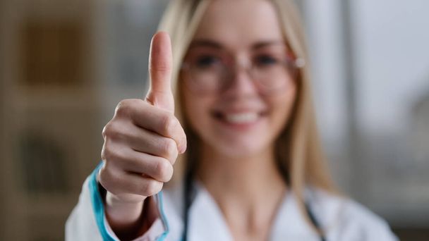 Kavkazský úsměv šťastný tisíciletá žena lékař v brýlích zdravotní sestra ortodontista při pohledu na kameru zubní úsměv ukazující palec nahoru doporučuje vakcinace úspěch rád dobré znamení, jako gesto - Fotografie, Obrázek
