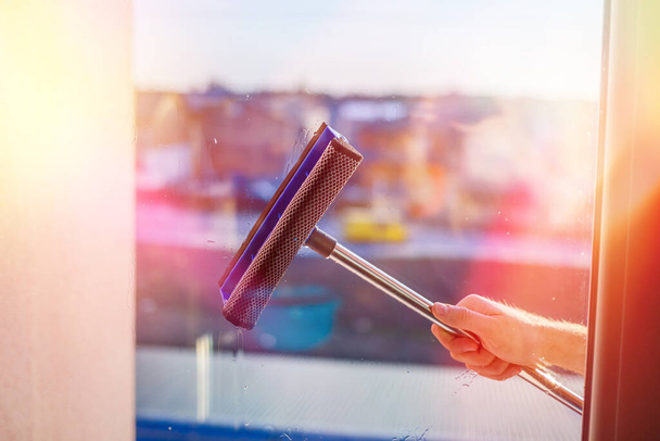 Window cleaning in high-rise buildings, houses with a brush. Window cleaning brush. Large window in a multi-storey building, cleaning service. Dust removal and glass washing. - Valokuva, kuva
