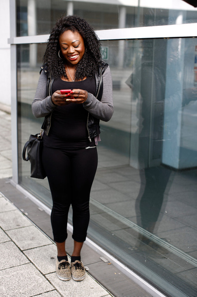 Mujer africana de moda leyendo un mensaje de texto
 - Foto, imagen
