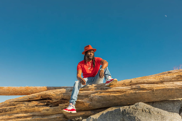 Przystojny, młody Afrykańczyk z dredami i kapeluszem na świeżym powietrzu. Zdjęcie uliczne. White Rock BC, Kanada-marzec 3,2022 - Zdjęcie, obraz