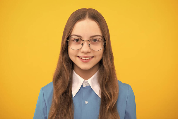 Teinityttö. Onnellinen tyttö lapsi silmälaseissa keltainen tausta. Tyttöjen koulutus - Valokuva, kuva