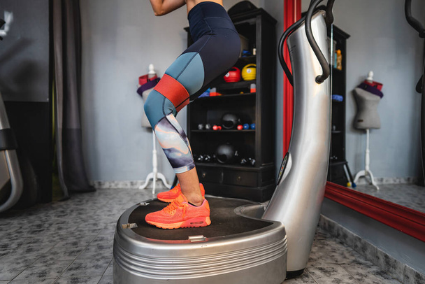Una mujer que entrena en la máquina de la placa de alimentación uso femenino powerplate para el ejercicio - Foto, imagen