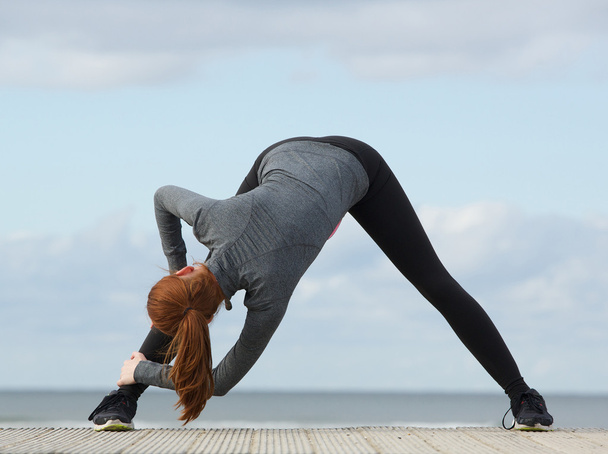 Deportiva mujer inclinándose y estirando ejercicio
 - Foto, imagen