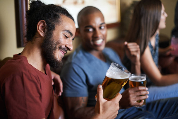 Buenos tiempos con buenos amigos. Tiro de amigos bebiendo y divirtiéndose en un pub. - Foto, imagen