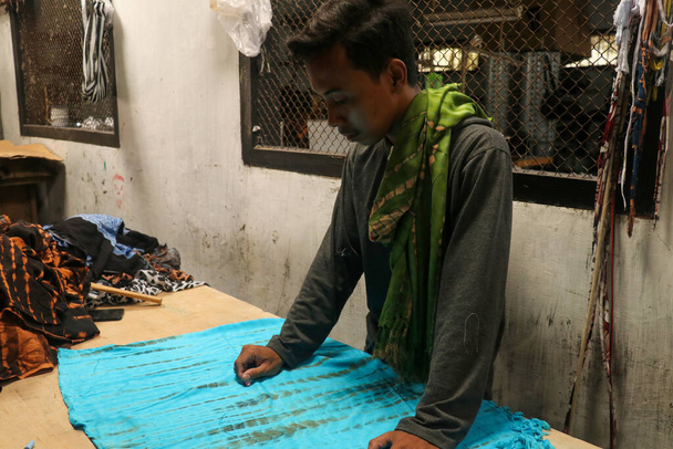Aziatisch man tailor mode kleding jurk ontwerper werken met stof op tafel - Foto, afbeelding