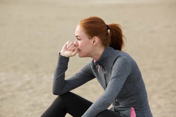 Açık havada oturma ve egzersiz yaptıktan sonra rahatlatıcı sportif kadın - Fotoğraf, Görsel