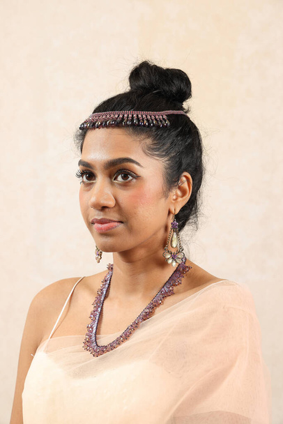 Όμορφη νεαρή γυναίκα φορώντας ινδικό στυλ βασιλική φόρεμα κοσμήματα φως μακιγιάζ ρετρό μόδα εποχής - Φωτογραφία, εικόνα