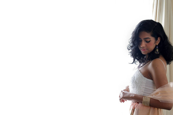 美しい若い女性を身に着けているインドスタイルのロイヤルティドレスジュエリーライトメイクレトロヴィンテージファッション窓の光の横に - 写真・画像