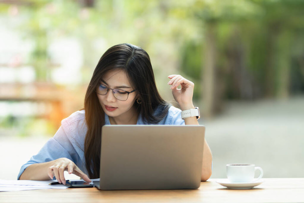 Asia Woman pracuje na komputerze osobistym i smartfonie w pracy internetowej z domu - Zdjęcie, obraz