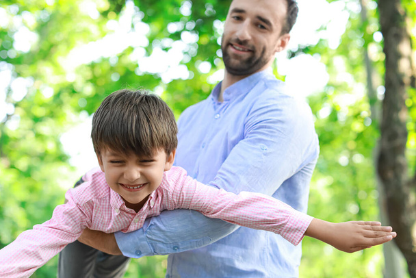 Мальчик веселится с отцом в парке, крупным планом. - Фото, изображение