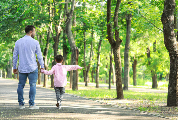 Padre che cammina con il suo figlioletto nel parco - Foto, immagini