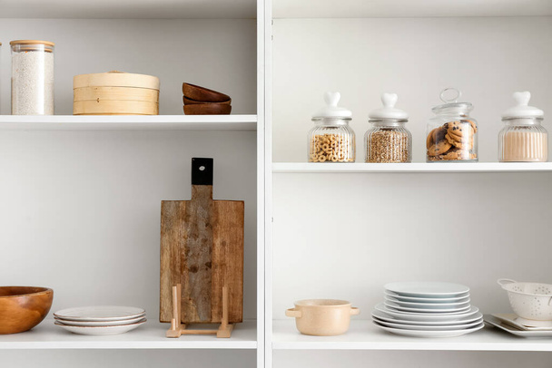 Shelf unit with clean dishware in kitchen - Фото, изображение