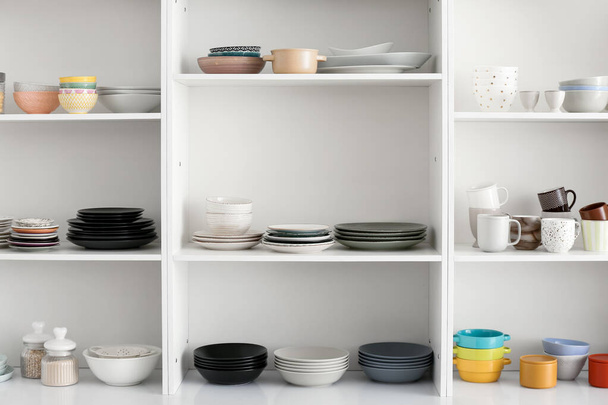 Regal mit sauberem Geschirr in der Küche - Foto, Bild