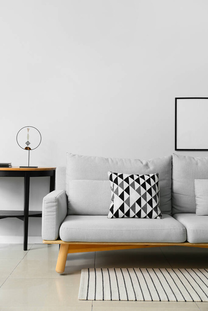 Belső tér modern nappali stílusos kanapéval, asztal és képkeret - Fotó, kép