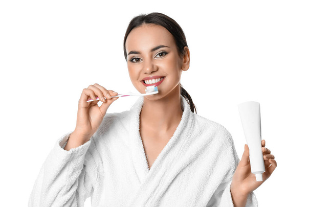 Pretty young woman with paste brushing teeth on white background - Photo, Image