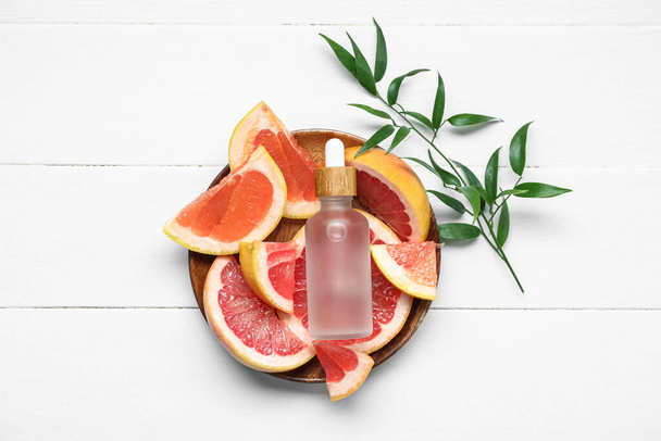 Flasche Grapefruitöl auf weißem Holzhintergrund - Foto, Bild