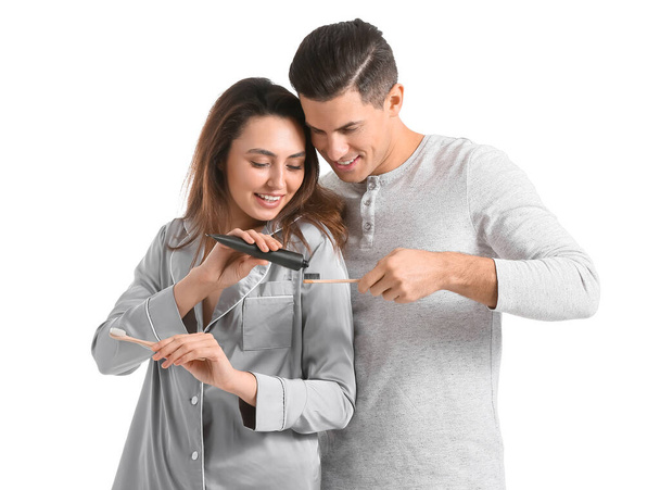 Junges Paar mit Holzkohle-Zahnpasta isoliert auf weiß - Foto, Bild