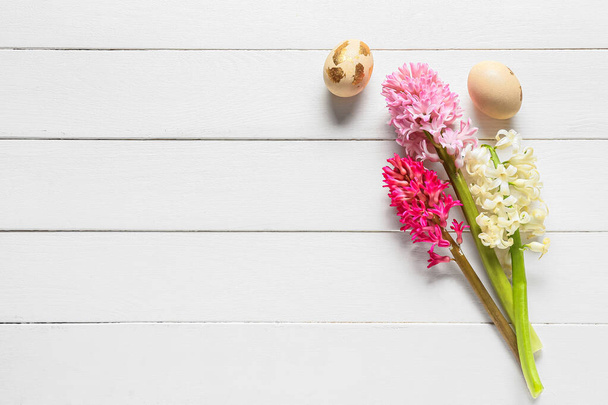 Belles fleurs de jacinthe et oeufs de Pâques sur fond de bois clair - Photo, image