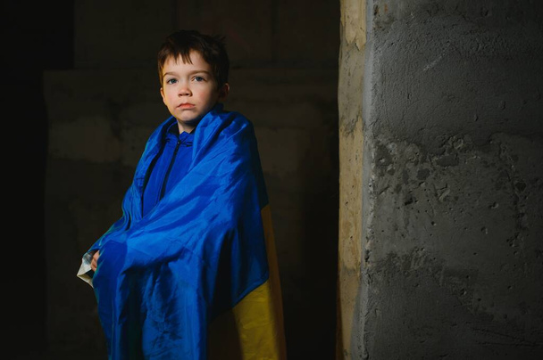 Russia's war against Ukraine in 2022. A sad boy is hiding in a bomb shelter from Russian missiles. Stop the war. - Fotó, kép