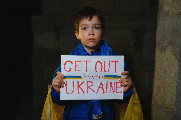 Russia's war against Ukraine in 2022. A sad boy is hiding in a bomb shelter from Russian missiles. Stop the war. - Photo, Image