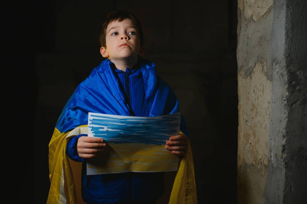 Ukrainian Crying boy holds a painted flag of Ukraine. War of Russia against Ukraine. Ukrainian Crying boy asks to stop the war in Ukraine. Child with message Stop War. - Valokuva, kuva