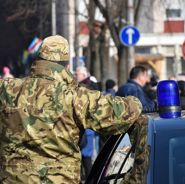 Vojenský policista stojící vedle policejního auta - Fotografie, Obrázek