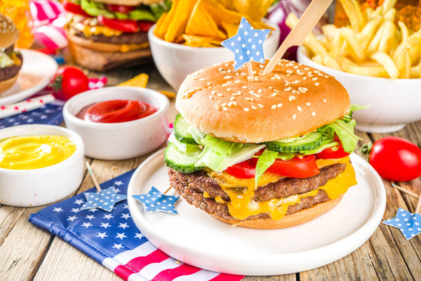 Celebrating Independence Day, July 4. Traditional American Memorial Day Patriotic Picnic with burgers,  french fries and snacks, Summer USA picnic and bbq concept, Old wooden background  - Foto, Bild