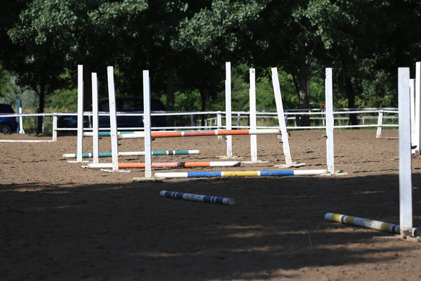 Прыжки через столбы, барьеры, ожидание гонщиков на тренировках по конкуру. Курс лошадиных препятствий на открытом воздухе летом - Фото, изображение