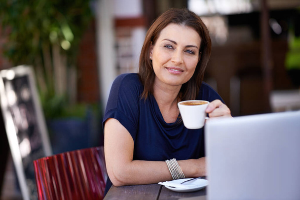 Blogging at the coffee shop. Shot of an attractive woman using her laptop at a coffee shop. - Foto, imagen