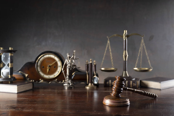 Law and justice concept. War crimes. Gavel, Themis sculpture, old clock, law code and scale in lawyers office. Gray background. - Photo, Image