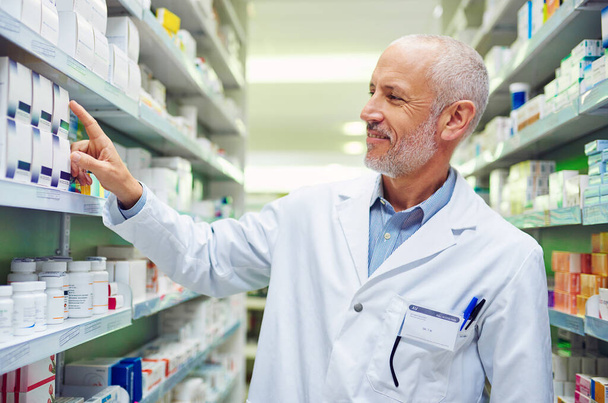 Pharmaceutical expertise you can rely on. Shot of a mature pharmacist doing inventory in a pharmacy. - Photo, Image