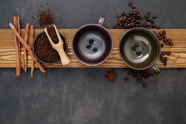 Смажені кавові зерна з кавовим порошком та смачними інгредієнтами для приготування смачної кави на фоні темного каменю
. - Фото, зображення